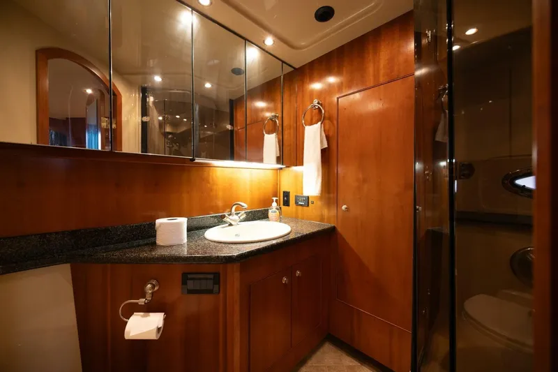 Sky Brown Yacht Photos Pics Luxurious bathroom in 2005 Cruisers Yachts 455 Express Motoryacht with wood cabinetry and modern fixtures.