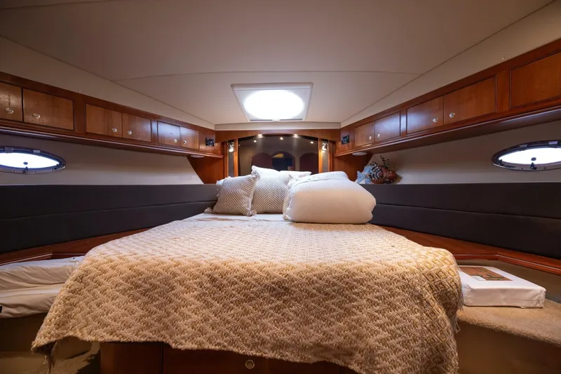 Sky Brown Yacht Photos Pics Luxurious bedroom interior of 2005 Cruisers Yachts 455 Express Motoryacht with elegant bedding.