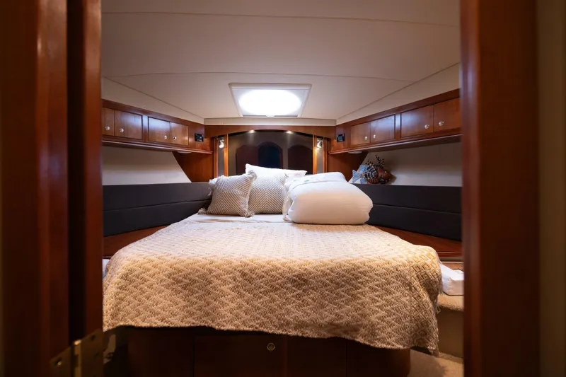 Sky Brown Yacht Photos Pics Luxurious cabin interior of 2005 Cruisers Yachts 455 Express Motoryacht, featuring cozy bedding.