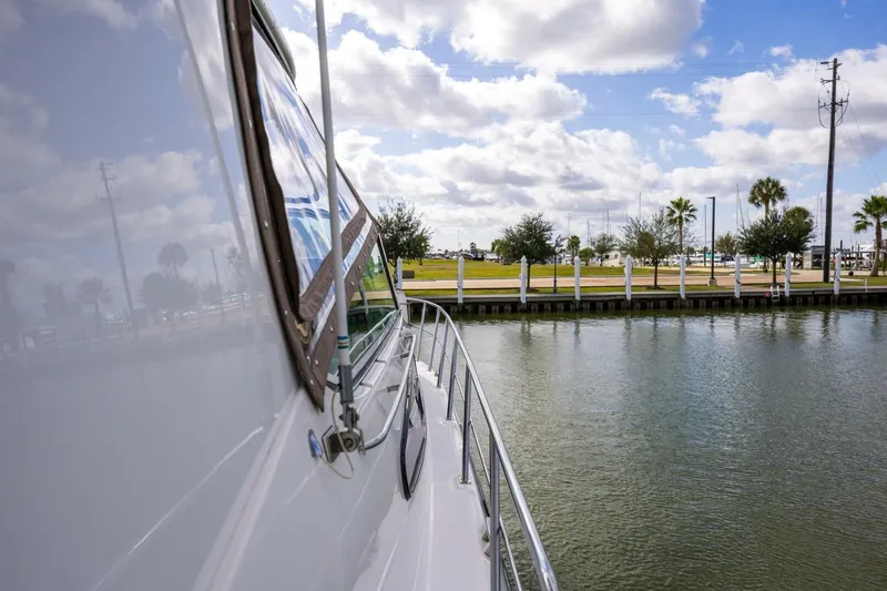Sky Brown Yacht Photos Pics 2005 Cruisers Yachts 455 Express Motoryacht docked by a scenic waterfront.