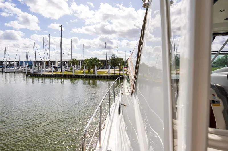 Sky Brown Yacht Photos Pics 2005 Cruisers Yachts 455 Express Motoryacht docked at a marina under a cloudy sky.