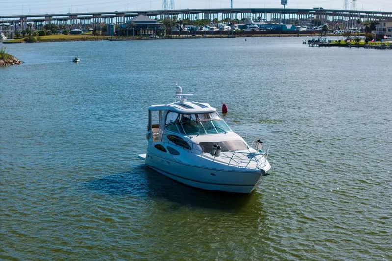 Sky Brown Yacht Photos Pics 2005 Cruisers Yachts 455 Express Motoryacht on calm water near a bridge.