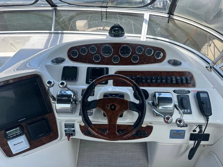Vrpro Yacht Photos Pics 2007 Meridian 411 Sedan helm with wood accents, steering wheel, and navigation controls.