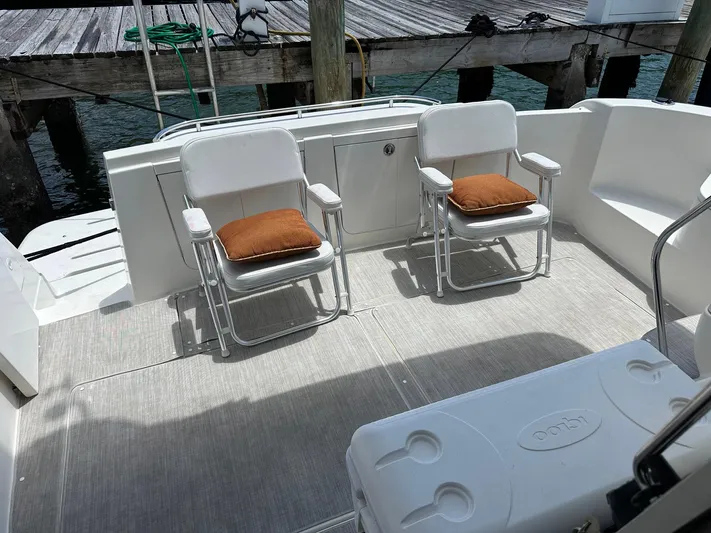 Vrpro Yacht Photos Pics 2007 Meridian 411 Sedan yacht deck with chairs and cushions, docked by wooden pier.