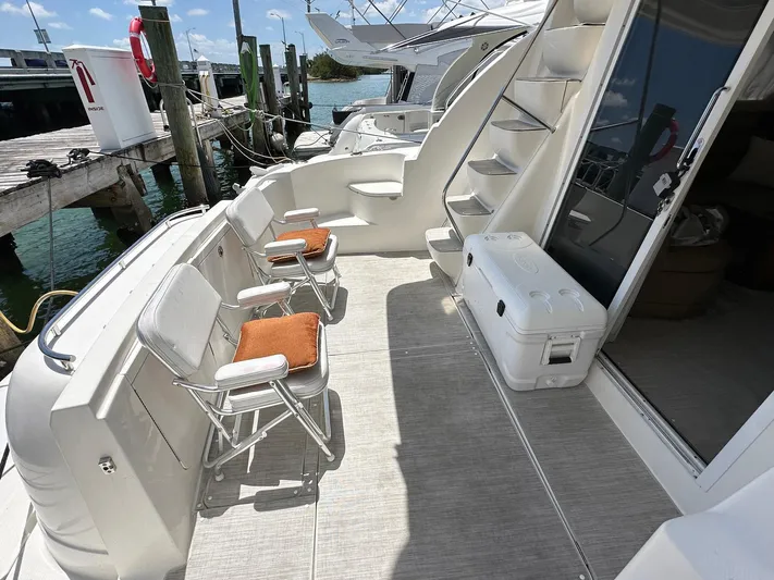 Vrpro Yacht Photos Pics 2007 Meridian 411 Sedan yacht deck with chairs and cooler, docked by the water.