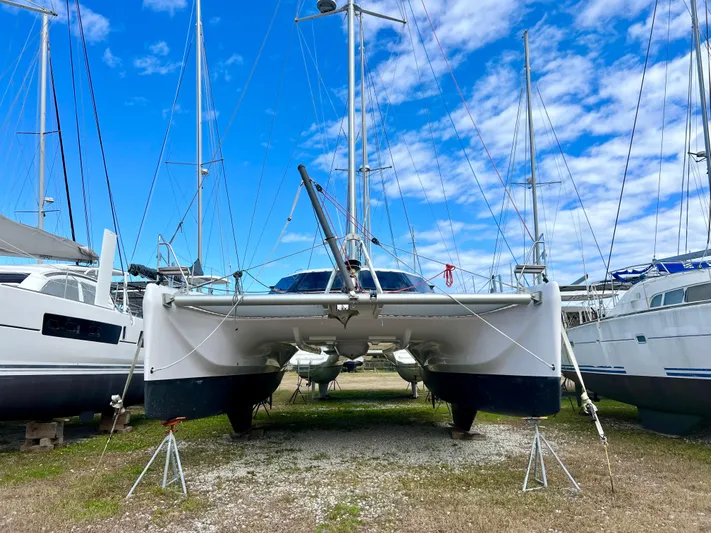 Kestrel Yacht Photos Pics 2020 Seawind 1260 catamaran on land, surrounded by other boats, under a blue sky.