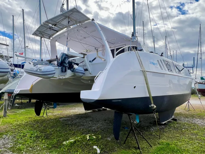Kestrel Yacht Photos Pics 2020 Seawind 1260 catamaran on land, under cloudy sky, with other boats nearby.