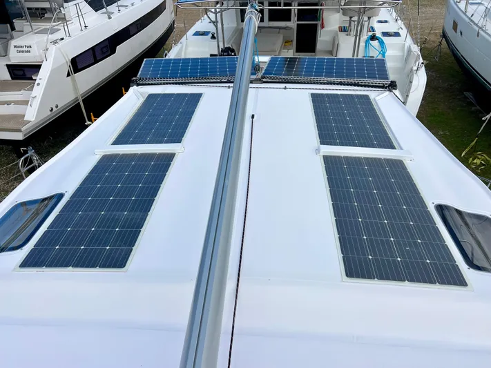 Kestrel Yacht Photos Pics 2020 Seawind 1260 catamaran with solar panels on deck, docked among other boats.
