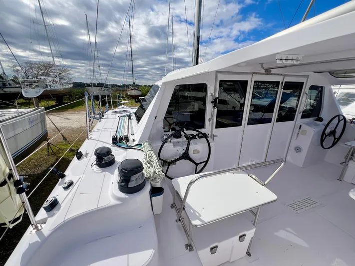 Kestrel Yacht Photos Pics 2020 Seawind 1260 catamaran deck with steering wheel and equipment under cloudy sky.