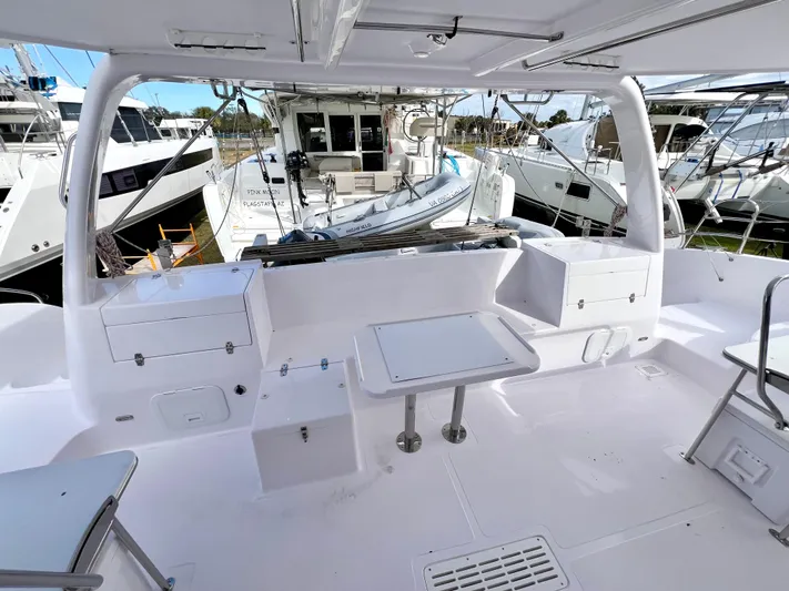 Kestrel Yacht Photos Pics 2020 Seawind 1260 catamaran cockpit with seating and tables, docked at a marina.