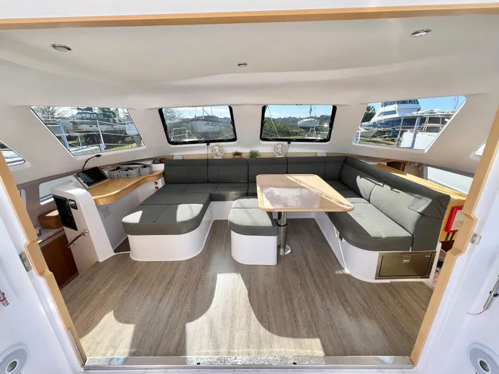 Kestrel Yacht Photos Pics Spacious interior of 2020 Seawind 1260 catamaran with modern seating and large windows.