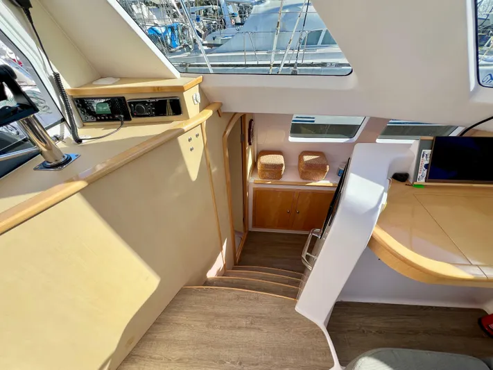 Kestrel Yacht Photos Pics Interior of a 2020 Seawind 1260 catamaran, featuring a modern navigation area and wooden stairs.