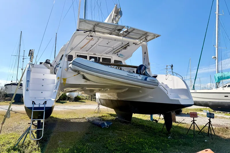 Kestrel Yacht Photos Pics 2020 Seawind 1260 catamaran on land with dinghy, under clear blue sky.