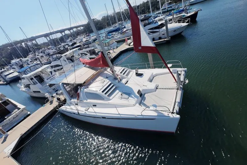 Next Of Kin Yacht Photos Pics Leopard 38 catamaran, 2000 model, docked in a marina with other boats.