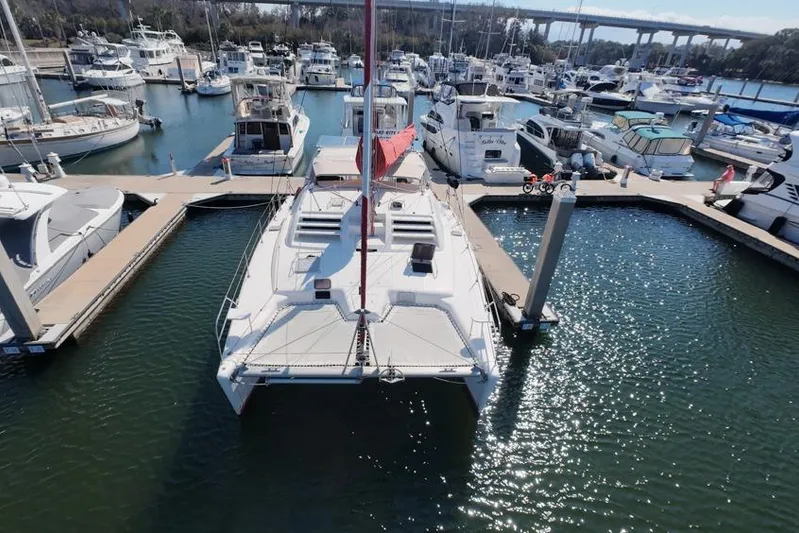 Next Of Kin Yacht Photos Pics Aerial view of a 2000 Leopard 38 catamaran docked in a marina.