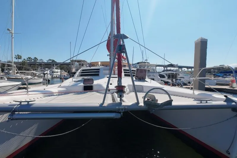 Next Of Kin Yacht Photos Pics Leopard 38 catamaran, 2000 model, docked in a marina under clear blue sky.