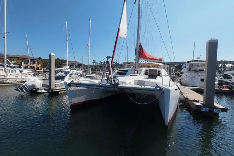 Next Of Kin Yacht Photos Pics Leopard 38 catamaran docked at marina, 2000 model, with red sail.