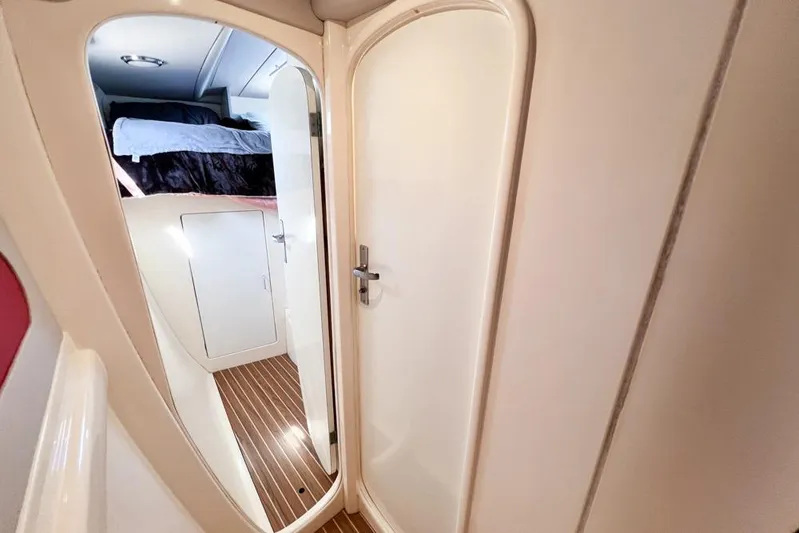 Next Of Kin Yacht Photos Pics Interior of a 2000 Leopard 38 yacht showing a cozy cabin with a bed and wooden flooring.