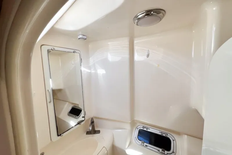 Next Of Kin Yacht Photos Pics Compact bathroom in a 2000 Leopard 38 yacht, featuring a mirror and porthole.