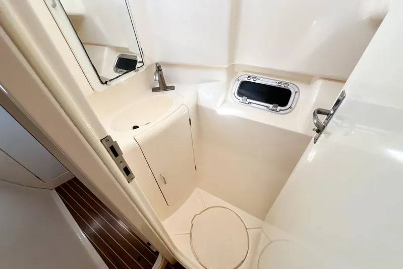 Next Of Kin Yacht Photos Pics Compact bathroom in a 2000 Leopard 38 yacht with sink, mirror, and porthole.