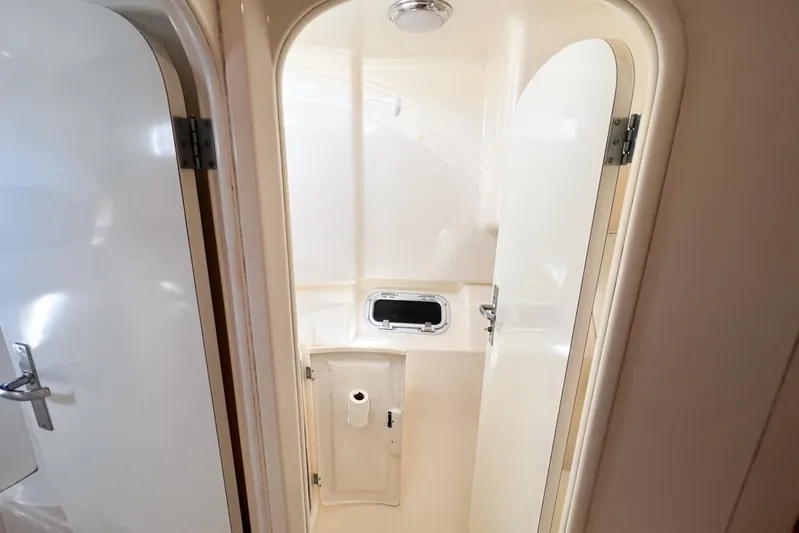 Next Of Kin Yacht Photos Pics Compact bathroom in a 2000 Leopard 38 yacht, featuring white interior and small window.