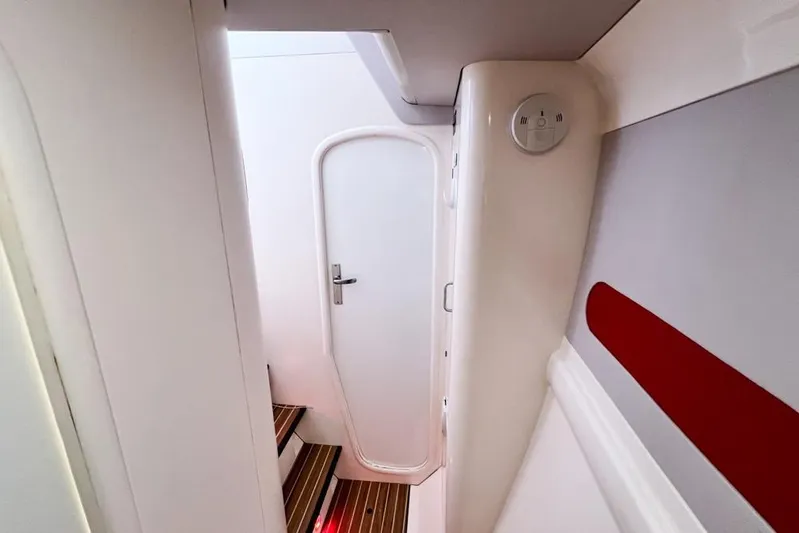 Next Of Kin Yacht Photos Pics Interior of a 2000 Leopard 38 yacht, featuring a white door and wooden steps.