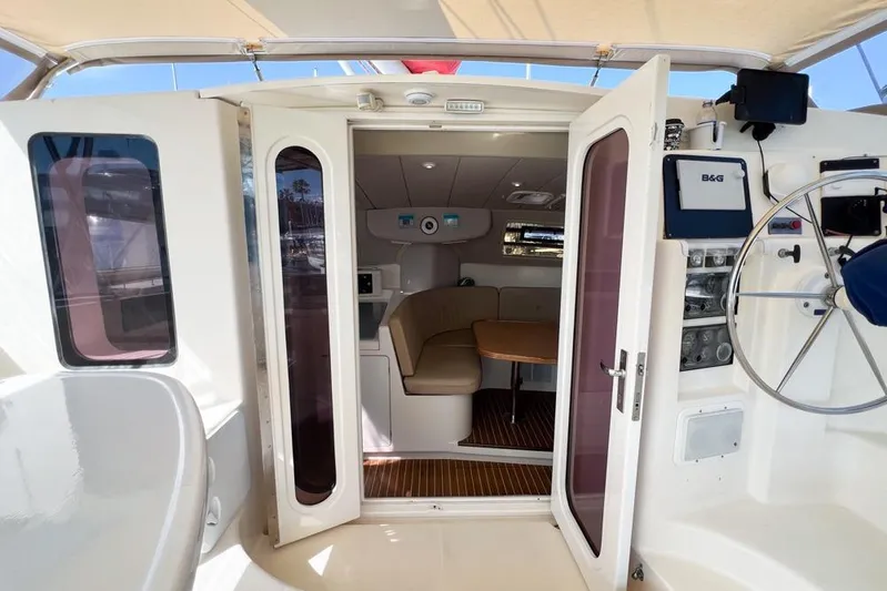 Next Of Kin Yacht Photos Pics Interior view of a 2000 Leopard 38 catamaran, featuring a cozy seating area and helm.