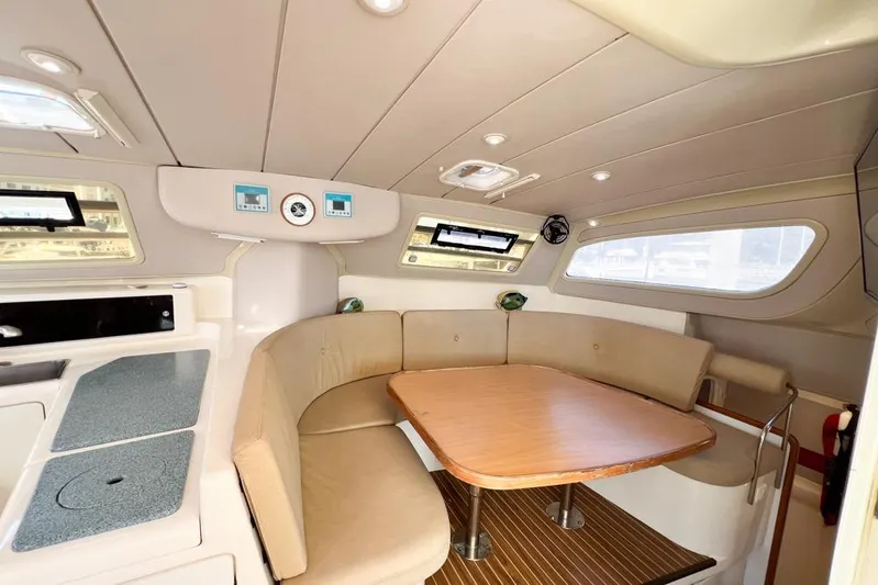 Next Of Kin Yacht Photos Pics Interior of 2000 Leopard 38 yacht with cozy seating and wooden table.