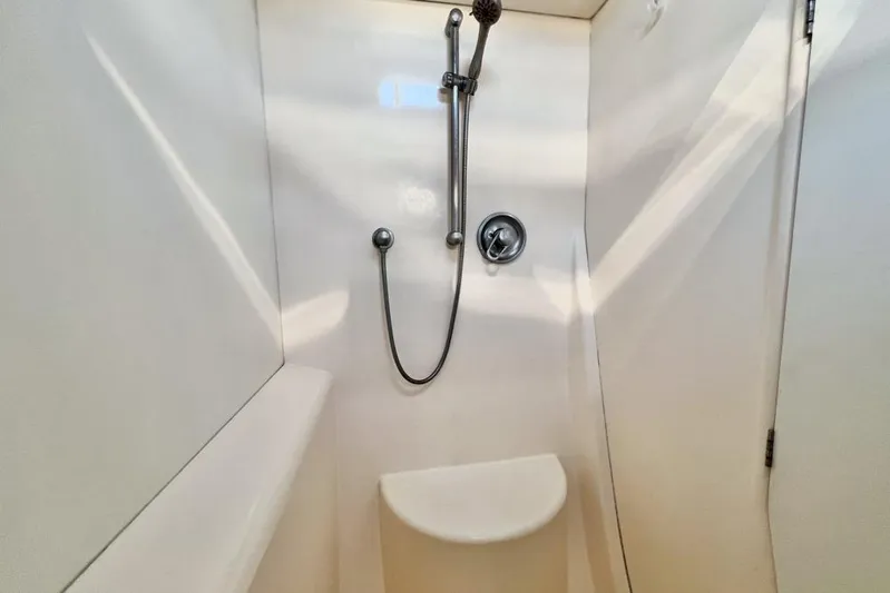 Next Of Kin Yacht Photos Pics Compact shower area in a 2000 Leopard 38 yacht, featuring a handheld showerhead.