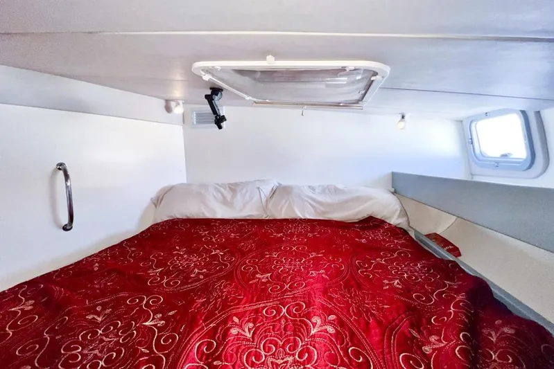 Next Of Kin Yacht Photos Pics Cozy cabin interior of 2000 Leopard 38 with red patterned bedding and porthole window.