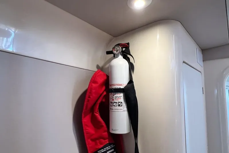 Next Of Kin Yacht Photos Pics Fire extinguisher mounted inside a 2000 Leopard 38 yacht, with red safety cover.