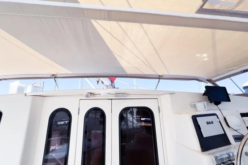 Next Of Kin Yacht Photos Pics Leopard 38 catamaran cockpit with canopy, featuring navigation equipment, 2000 model.