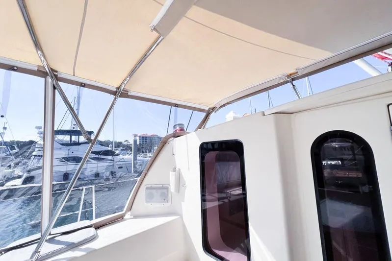 Next Of Kin Yacht Photos Pics Leopard 38 catamaran interior view, showcasing windows and canopy, docked at marina.