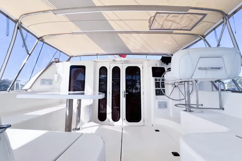 Next Of Kin Yacht Photos Pics Interior view of a 2000 Leopard 38 catamaran, featuring a shaded cockpit and seating area.