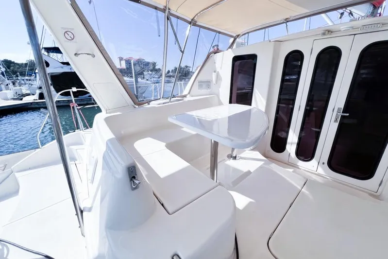 Next Of Kin Yacht Photos Pics Leopard 38 yacht cockpit, 2000 model, featuring sleek seating and table, docked at marina.