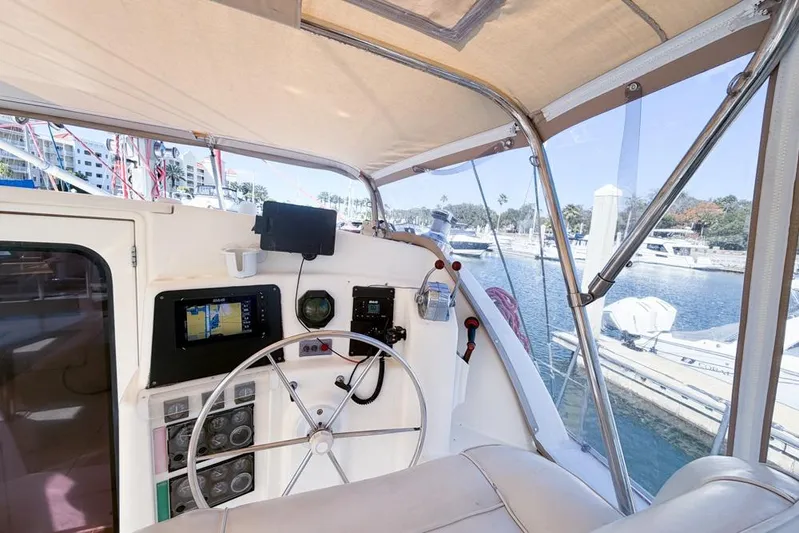 Next Of Kin Yacht Photos Pics Helm of 2000 Leopard 38 catamaran with navigation equipment and marina view.