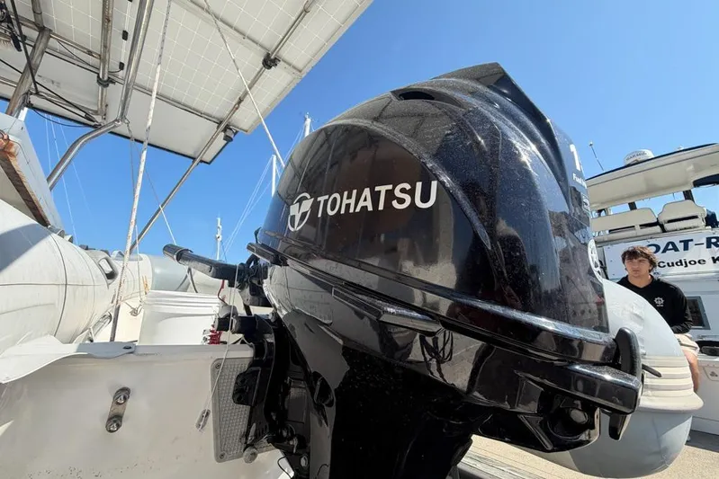 Next Of Kin Yacht Photos Pics Tohatsu outboard motor on a Leopard 38 catamaran, 2000 model, under clear blue sky.