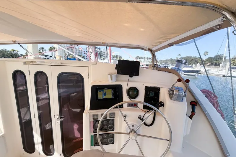Next Of Kin Yacht Photos Pics Cockpit of a 2000 Leopard 38 catamaran with steering wheel and navigation equipment.