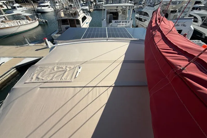Next Of Kin Yacht Photos Pics Leopard 38 catamaran, 2000 model, docked with solar panels and red sail cover.