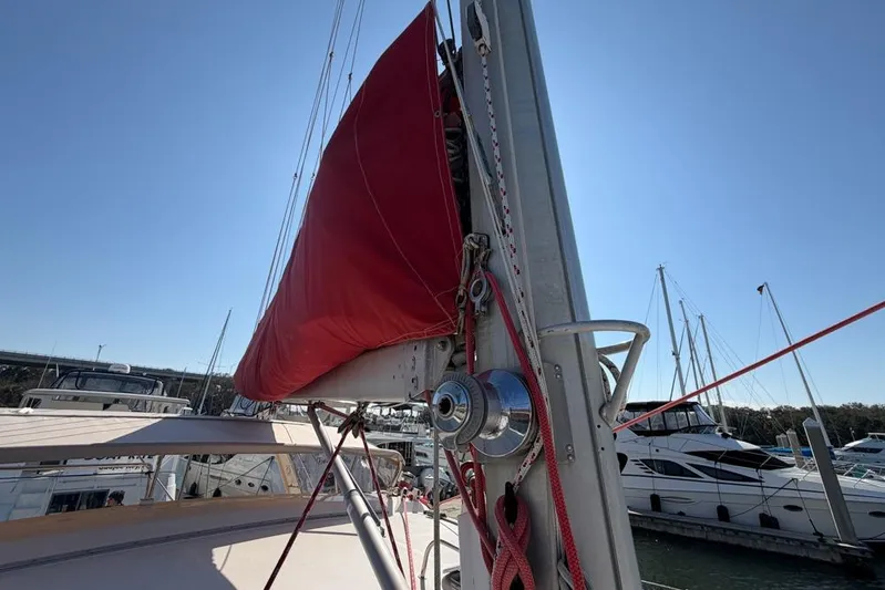 Next Of Kin Yacht Photos Pics Sailboat with red sail cover, Leopard 38 model, docked in marina under clear sky.