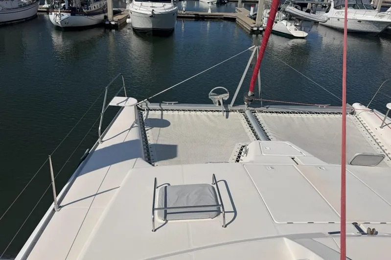 Next Of Kin Yacht Photos Pics Leopard 38 catamaran from 2000 docked in a marina, showcasing deck and netting.