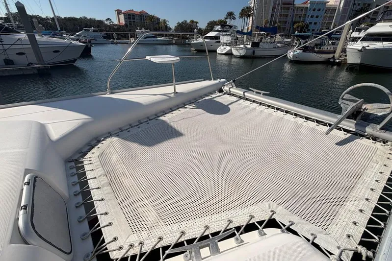 Next Of Kin Yacht Photos Pics Leopard 38 catamaran's deck with netting, docked in a marina, 2000 model.