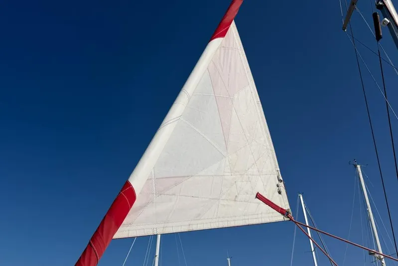 Next Of Kin Yacht Photos Pics Sail of a 2000 Leopard 38 catamaran against a clear blue sky.