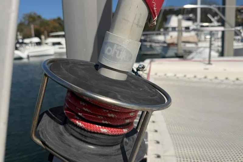 Next Of Kin Yacht Photos Pics Close-up of a Leopard 38 sailboat winch with red rope, docked at a marina.