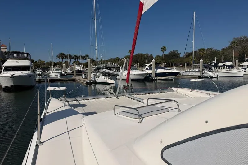 Next Of Kin Yacht Photos Pics Leopard 38 catamaran docked in a marina, surrounded by various boats.