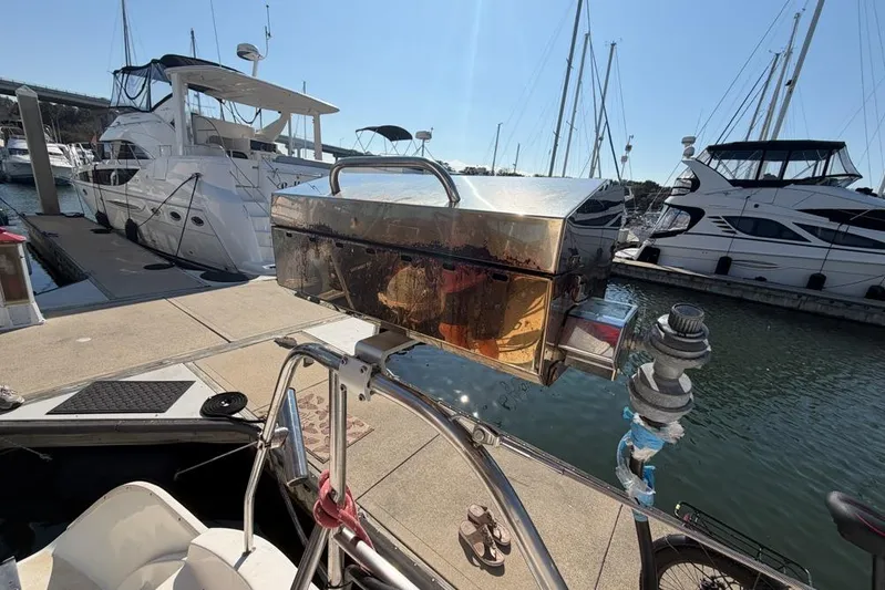 Next Of Kin Yacht Photos Pics Docked Leopard 38 catamaran with a mounted grill, surrounded by luxury yachts.