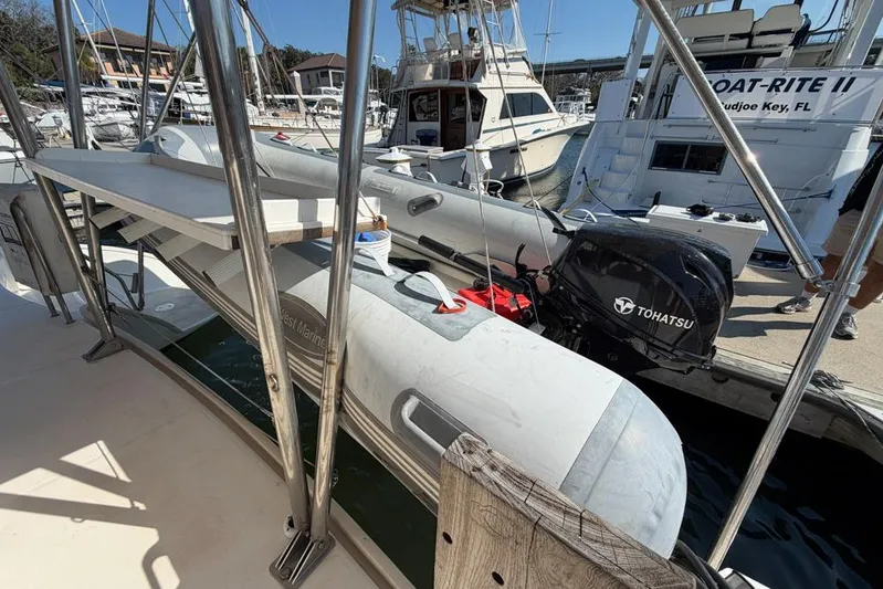 Next Of Kin Yacht Photos Pics Docked Leopard 38 catamaran with Tohatsu outboard motor, 2000 model, in a marina setting.