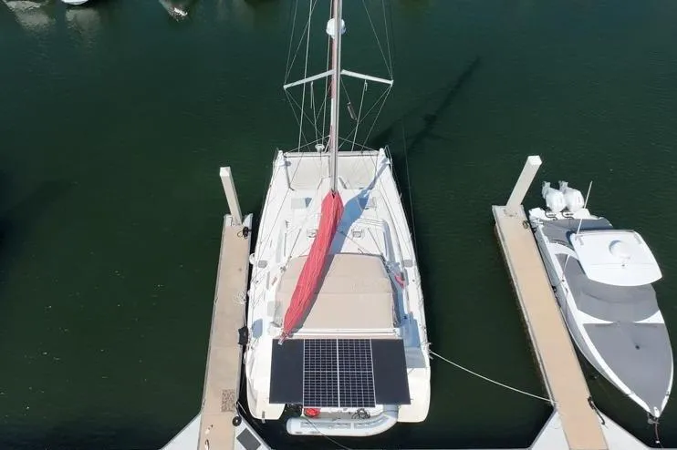 Next Of Kin Yacht Photos Pics Aerial view of a 2000 Leopard 38 catamaran docked at a marina.
