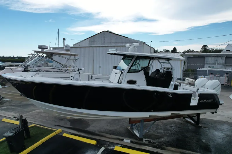  Yacht Photos Pics 2021 Blackfin 332 CC boat on display at a marina, featuring sleek black and white design.