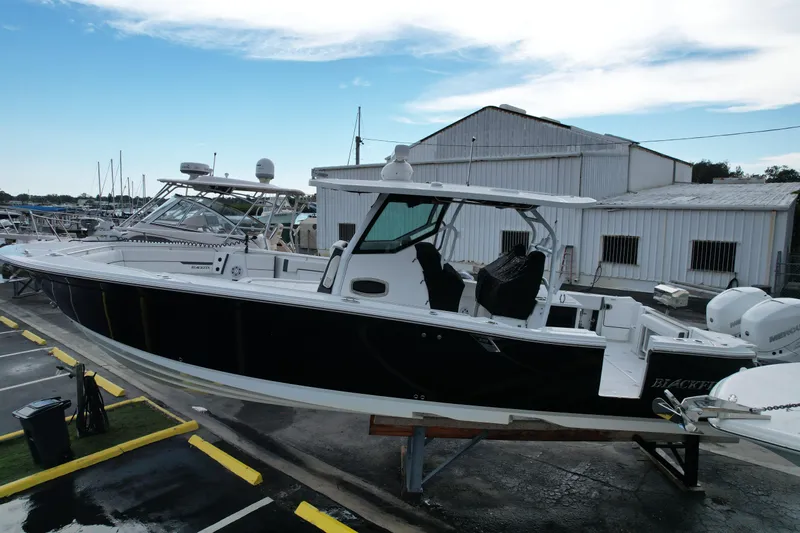  Yacht Photos Pics 2021 Blackfin 332 CC boat on display at a marina with clear skies.
